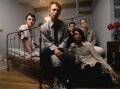 integrantes de radiohead sentados en una cama